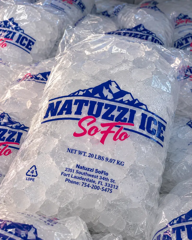 A 20 lb bag of Natuzzi Ice SoFlo ice on a pile of bags, printed with our Fort Lauderdale address